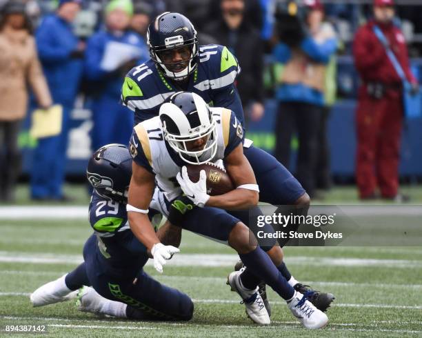 Wide receiver Robert Woods of the Los Angeles Rams makes a reception as he's tackled by free safety Earl Thomas of the Seattle Seahawks and Byron...