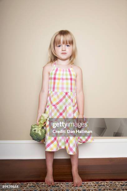 four year old girl hating broccoli. - blond hair girl fotografías e imágenes de stock