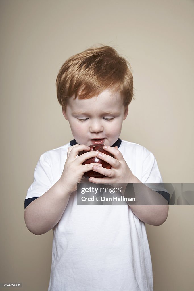Boy, 3 years old, holding an apple.