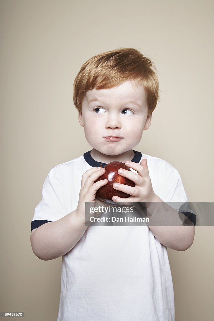 Boy, 3 years old, holding an apple.