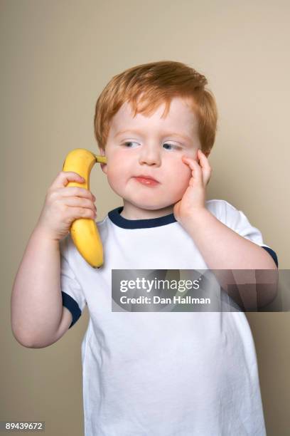 three year old boy using banana as phone. - banana phone stock pictures, royalty-free photos & images