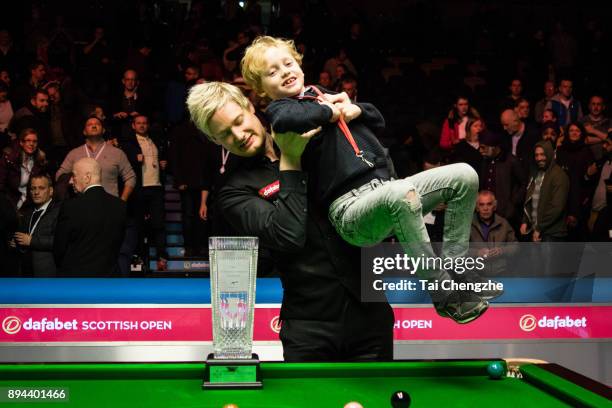 Neil Robertson of Australia celebrates with his son after winning the final match against Cao Yupeng of China on day seven of the 2017 Scottish Open...