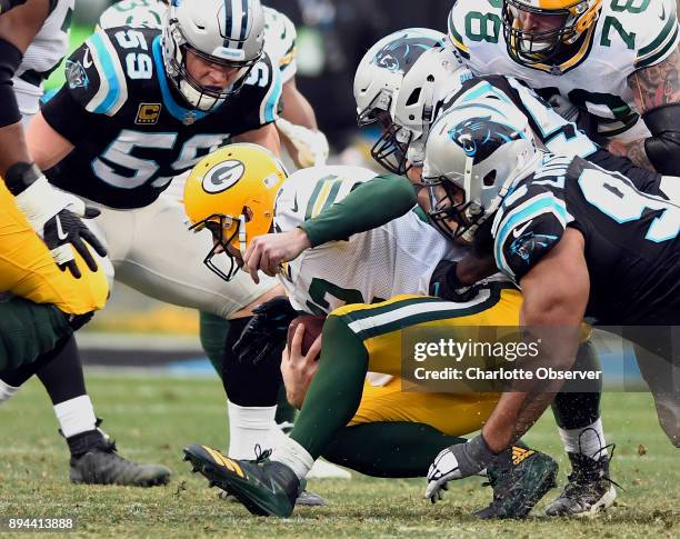 Green Bay Packers quarterback Aaron Rodgers goes down under the pressure of Carolina Panthers middle linebacker Luke Kuechly , outside linebacker...