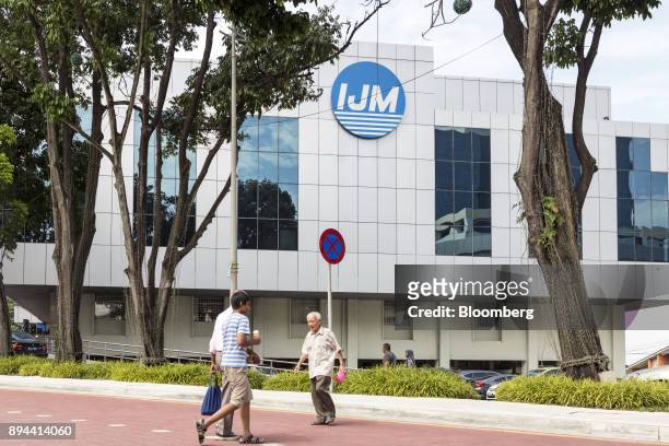 People cross the road in front of the IJM Corp. Offices in Kuala Lumpur, Malaysia, on Tuesday, May 30, 2017. IJM is Malaysia's biggest builder by...