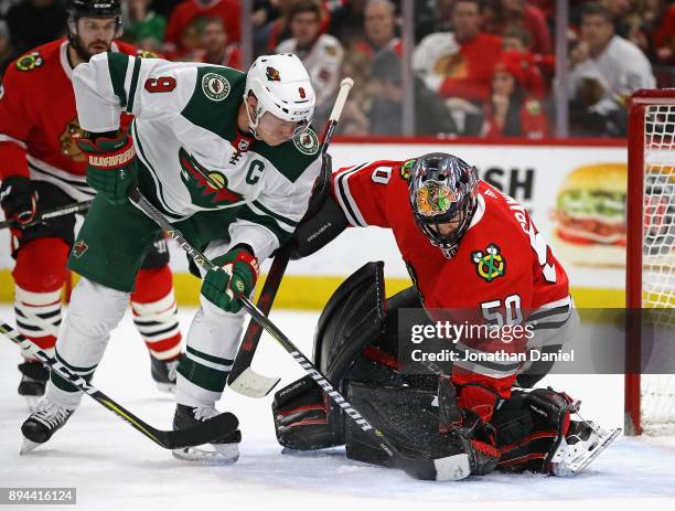 Corey Crawford of the Chicago Blackhawks makes a save against Mikko Koivu of the Minnesota Wild at the United Center on December 17, 2017 in Chicago,...