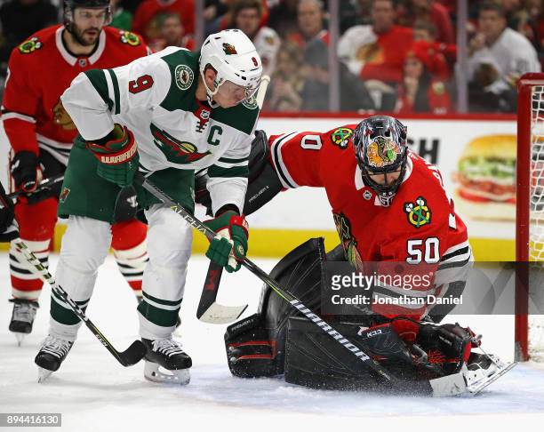 Corey Crawford of the Chicago Blackhawks makes a save against Mikko Koivu of the Minnesota Wild at the United Center on December 17, 2017 in Chicago,...
