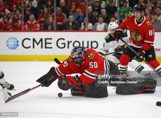 Corey Crawford of the Chicago Blackhawks drops to cover the puck against the Minnesota Wild at the United Center on December 17, 2017 in Chicago,...