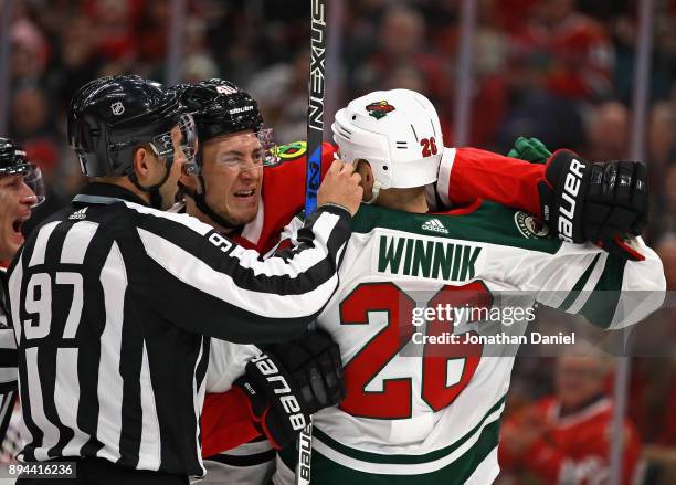 Lineman Kory Nagy gets between John Hayden of the Chicago Blackhawks and Daniel Winnik of the Minnesota Wild during a minor altercation at the United...