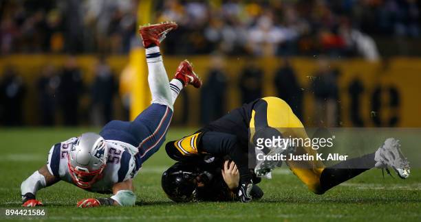 Ben Roethlisberger of the Pittsburgh Steelers is hit by Elandon Roberts of the New England Patriots as he scrambles out of the pocket in the second...