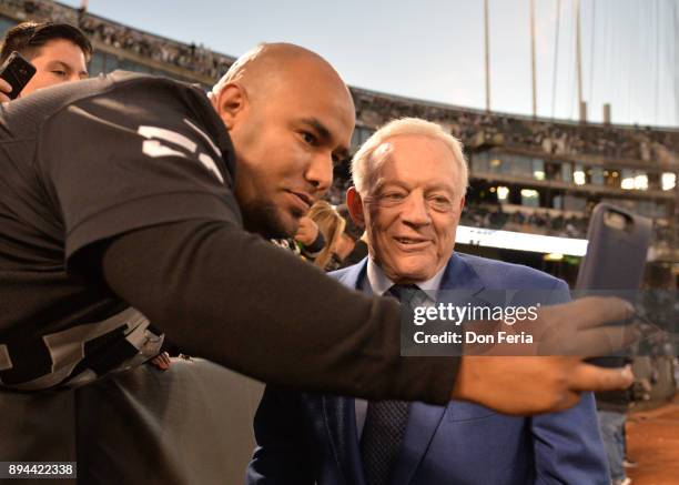 Dallas Cowboys owner Jerry Jones takes a photo with a fan in the stands prior to their game against the Oakland Raiders during their NFL game at...