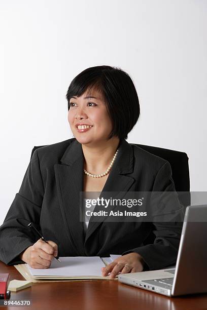 business woman smiling - réfléchir écrire adulte 40 ans papiers photos et images de collection