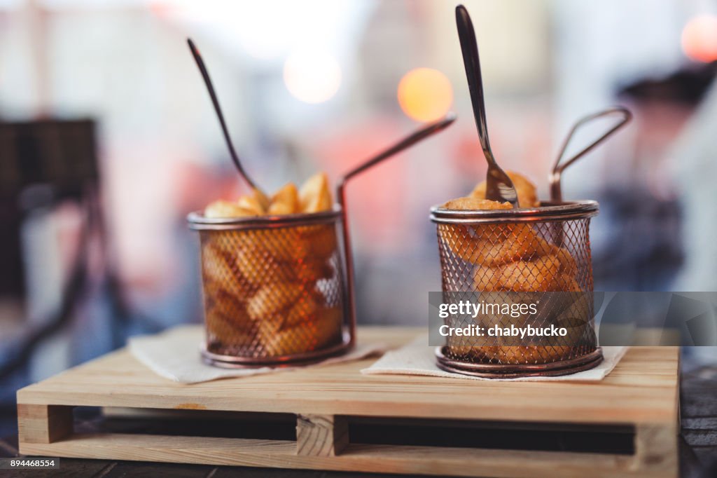 Potatoes and onion rings in pub