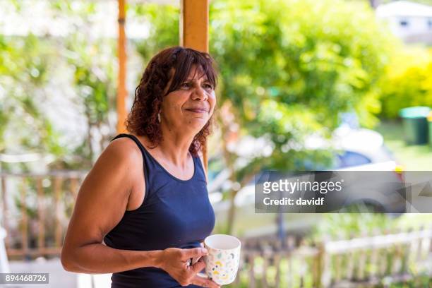 australiano aborigen madre disfrutando de una taza de café en casa - etnia aborigen australiana fotografías e imágenes de stock