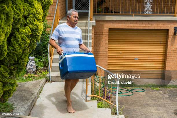 mature australian aboriginal man preparing to pack the car for a bbq - aboriginal man imagens e fotografias de stock