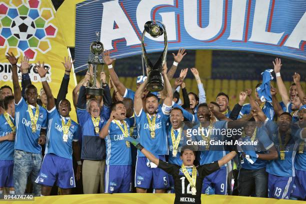Andres Cadavid of Millonarios lifts the trophy to celebrate with teammates after winning the second leg match between Millonarios and Santa Fe as...