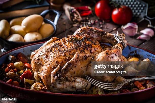 baked chicken with vegetables on rustic wooden table - roasted chicken stock pictures, royalty-free photos & images