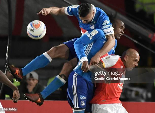 Omar Perez of Santa Fe struggles for the ball with Andres Cadavid and Felipe Banguero of Millonarios during the second leg match between Millonarios...