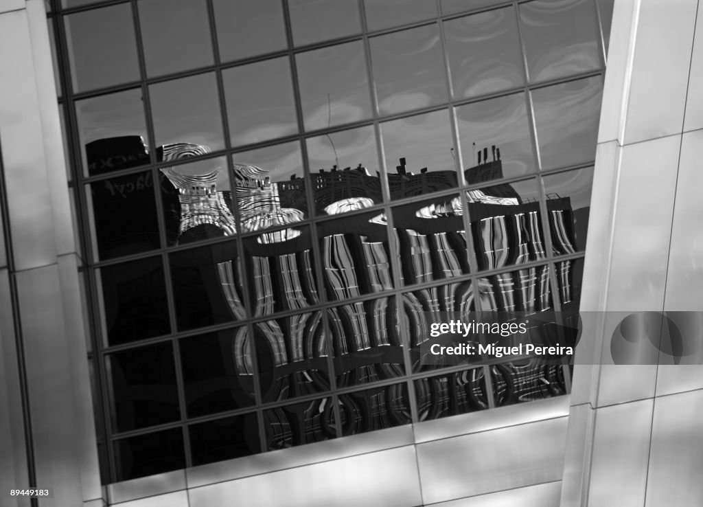 Madrid skyscrapers. Building reflected in the windows of a Torre Kio. La Puerta de Europa towers are two twin office buildings in Madrid.They were designed by the American architects Philip Johnson and John Burgee, built by Fomento de Construcciones y Con