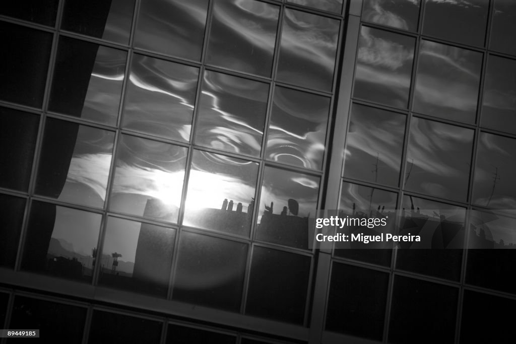 Madrid skyscrapers. Building reflected in the windows of a Torre Kio. La Puerta de Europa towers are two twin office buildings in Madrid.They were designed by the American architects Philip Johnson and John Burgee, built by Fomento de Construcciones y Con