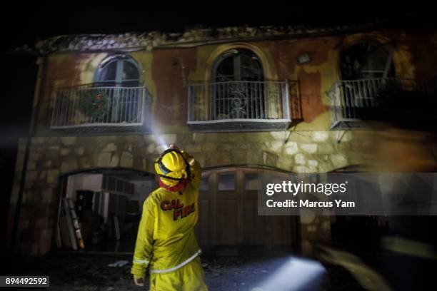 Fire crews check a burned home for structural integrity as they continue to monitor fire activity throughout the night, on December 17, 2017 in...