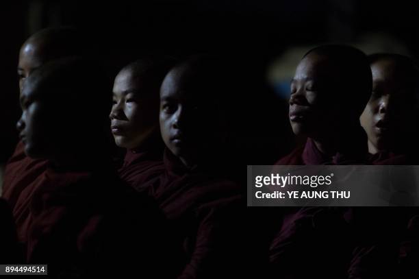 In this photo taken on May 25 Buddhist monk novices line up before heading out through Bagan to collect daily alms from devotees seeking to make...