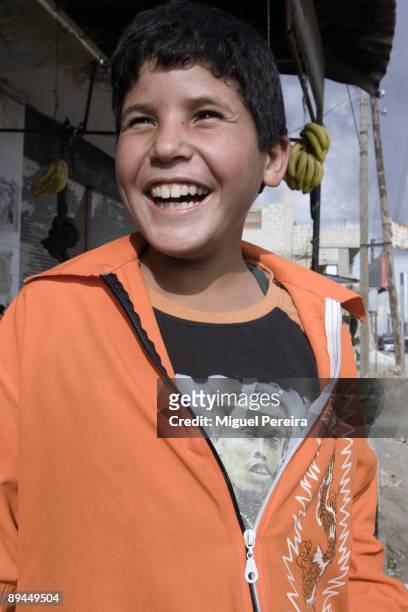 Child in a Ronaldinho´s shirt laughs in the streets of a village in the Damascus outskirts in Syria.
