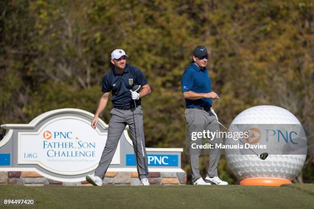 Nick and Matthew Faldo of England prepare to tee off on the 18th tee during the final round of the PNC Father/Son Challenge at The Ritz-Carlton Golf...