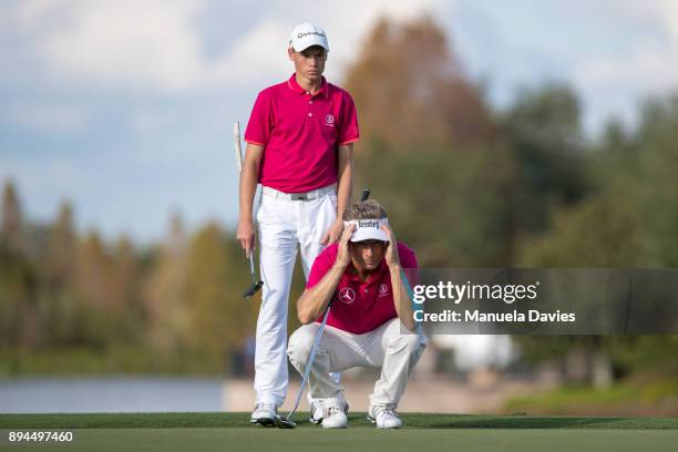 Bernhard and Jason Langer of Germany line up a putt on the 18th green during the final round of the PNC Father/Son Challenge at The Ritz-Carlton Golf...