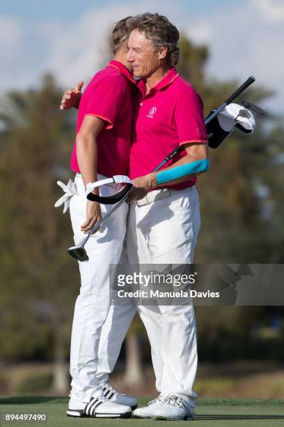 Bernhard and Jason Langer of Germany hug on the 18th green after their final round of the PNC Father/Son Challenge at The Ritz-Carlton Golf Club on...