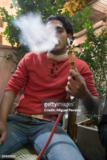 Young man smokes hookah in a Damascus cafe.