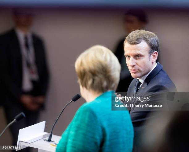 German Chancellor Angela Merkel is listening to the French President Emmanuel Macron during a press briefing at the end of a 2 days EU Summit in the...