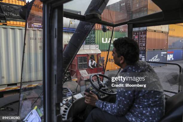 Truck driver watches a reach stack operator move a shipping container at the Jawaharlal Nehru Port, operated by Jawaharlal Nehru Port Trust , in Navi...