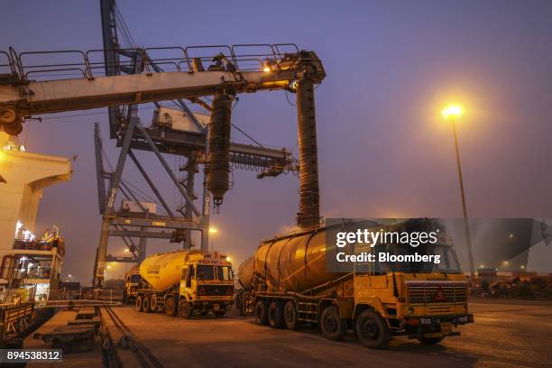 Cement tanker trucks are filled from a ship at the Jawaharlal Nehru Port, operated by Jawaharlal Nehru Port Trust , in Navi Mumbai, Maharashtra,...