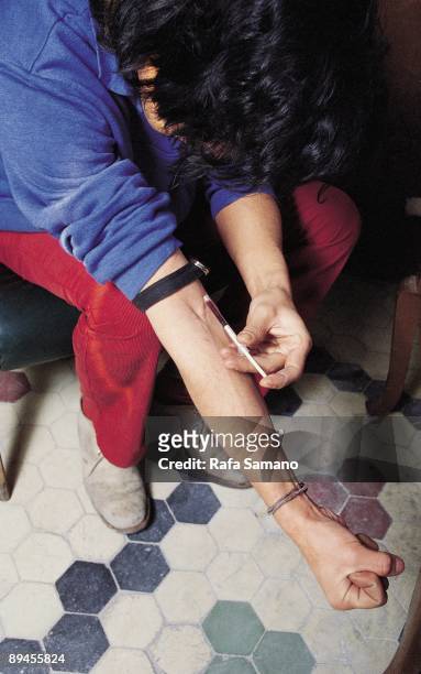 Young man injecting heroin A young addicted injecting heroin inside a house