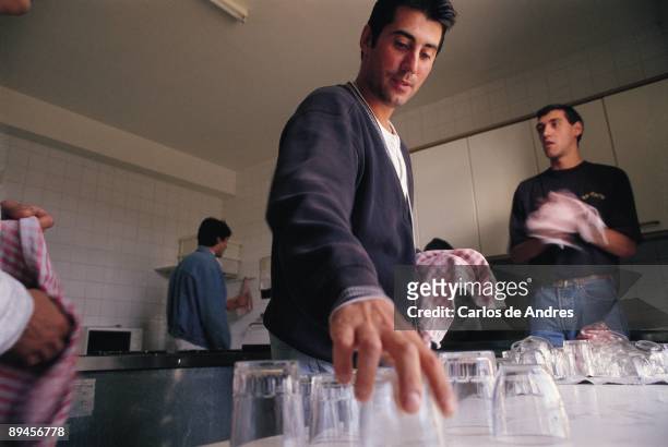 Young in a center of drug addicts rehabilitation Young men entered in the recovery center of junkie Project Man helping in the kitchen