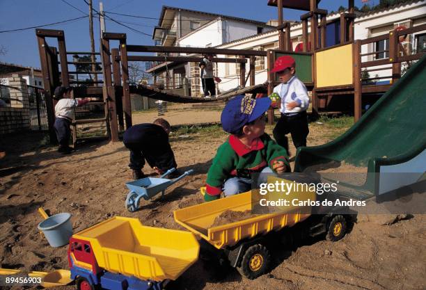 Children playing. Las Hurdes. Caceres A group of children playing with the sand and surrounded of toys in a park in the street