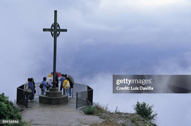 Cross of the viewpoint in Montserrat monastery Tourist in the Cross of the viewpoint in the Montserrat monastery. 11th century