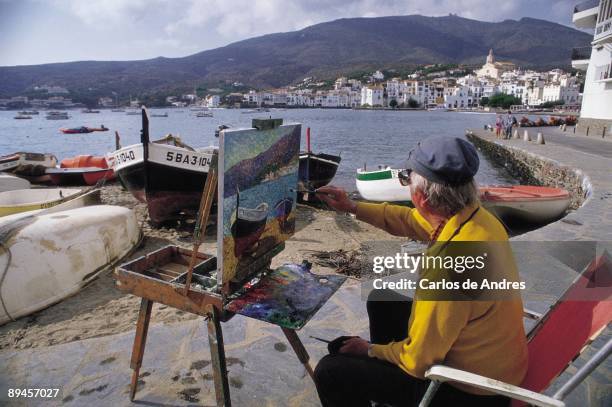 Cadaques beach, Gerona province Man draws a picture in the Cadaques seaport , Gerona province