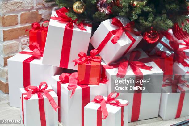 gift boxes piled under christmas tree - christmas presents under tree stock pictures, royalty-free photos & images