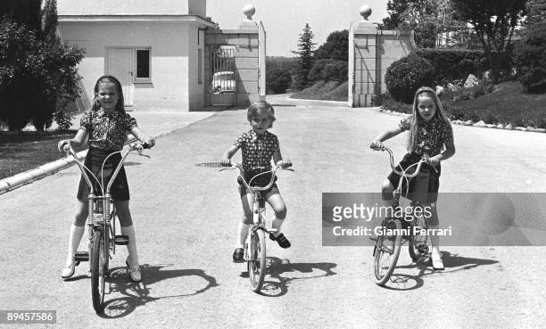 Madrid, Palace of the Zarzuela, Spain. The three children of the Princes of Spain Elena, Cristina and Felipe riding a bicycle in the gardens of the...