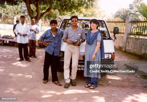 Photograph of Dr Badrul Munir Sohel and Dr Pamela Ching posing in front of a van among locals in a rural area in the Rajshahi Division of Bangladesh,...