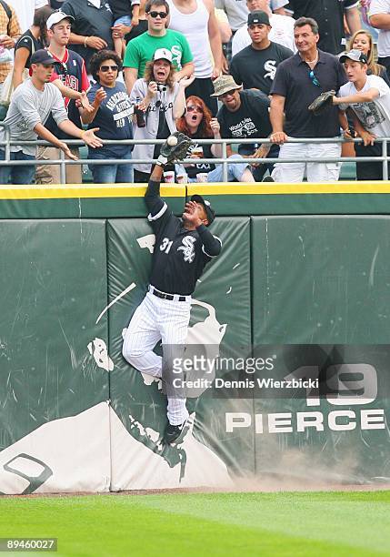Center fielder Dewayne Wise of the Chicago White Sox leaps over the wall to catch a ball hit by right fielder Gabe Kapler of the Tampa Bay Rays ,...