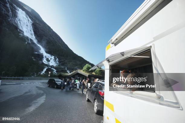 Mother with daughter looking through window of campervan at waterfall