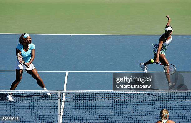 Venus Williams and Serena Williams return a shot during their doubles match against Liga Dekmeijere of Latvia and Julie Ditty of the USA on Day 3 of...