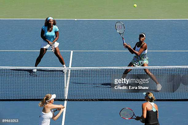 Venus Williams and Serena Williams return a shot during their doubles match against Liga Dekmeijere of Latvia and Julie Ditty of the USA on Day 3 of...