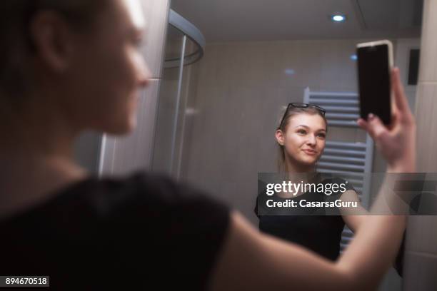 prachtige tienermeisje nemen van een selfie in badkamer - girl in mirror stockfoto's en -beelden