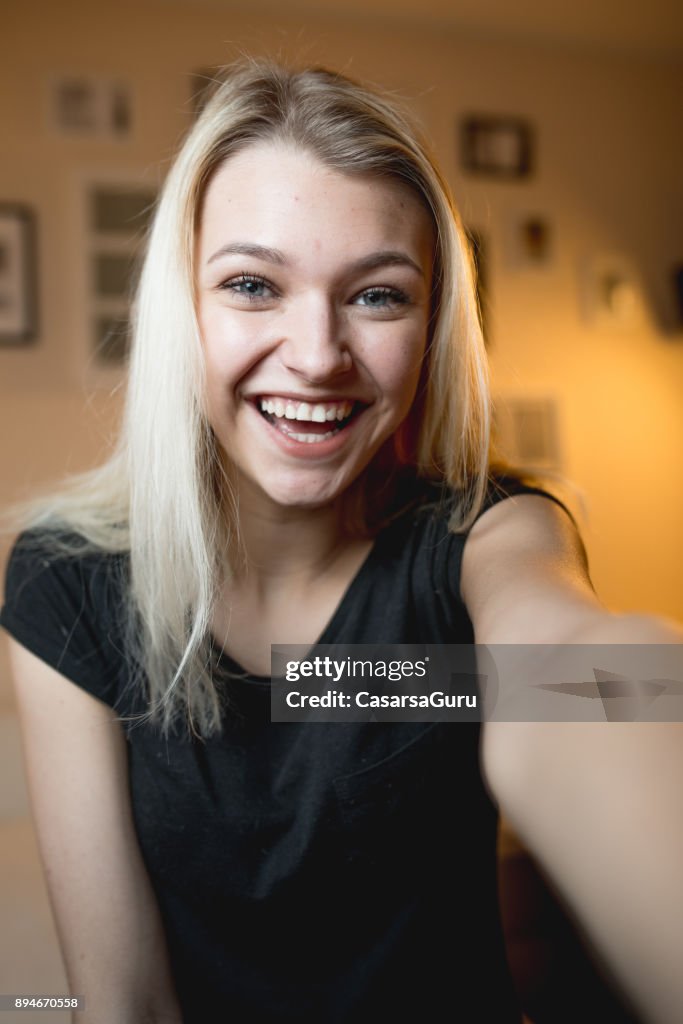 Beautiful Cheerful Teenage Girl Taking a Selfie in Bedroom