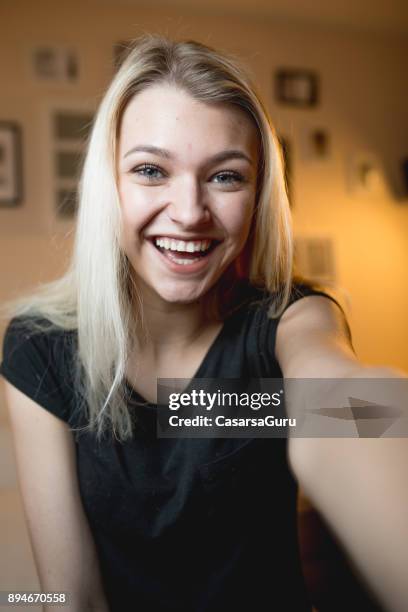 beautiful cheerful teenage girl taking a selfie in bedroom - selfie indoors stock pictures, royalty-free photos & images