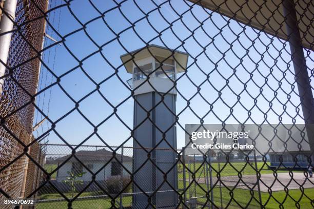 Looking thru a fence at a guard tower inside Angola Prison. The Louisiana State Penitentiary, also known as Angola, and nicknamed the "Alcatraz of...