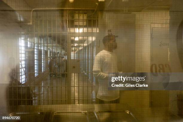 An Angola prisoner walks past a glass door inside one of the buildings inside the prison. The Louisiana State Penitentiary, also known as Angola, and...